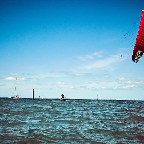 Kitesurfer mit rotem Kite auf der Ostsee