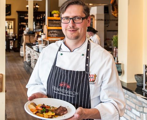 Oliver Firla serviert Fleischgericht in Odins Gasthaus in Haddeby